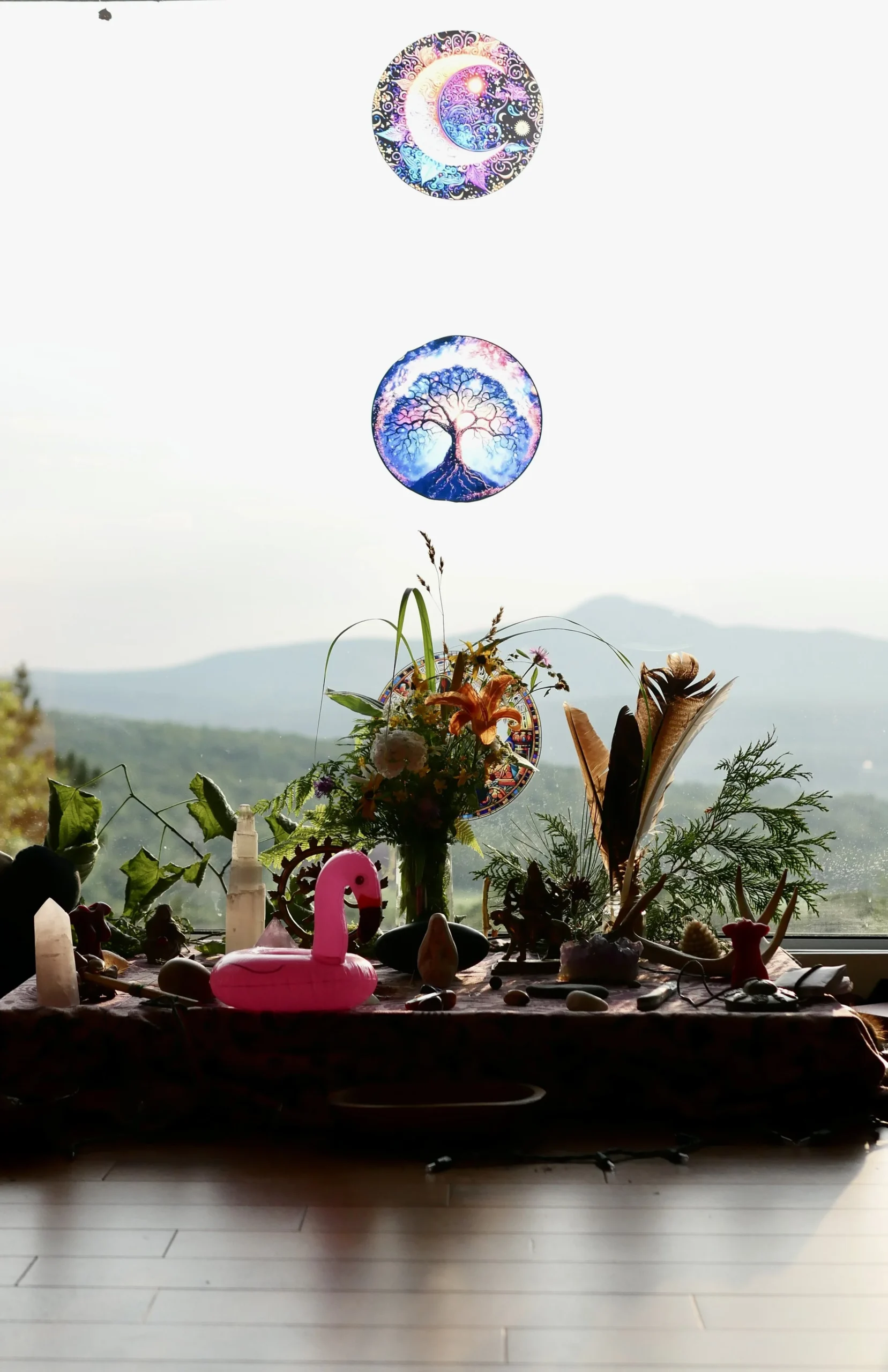 Un autel avec des fleurs, des cristaux, des figurines, et un ballon en forme de cygne rose