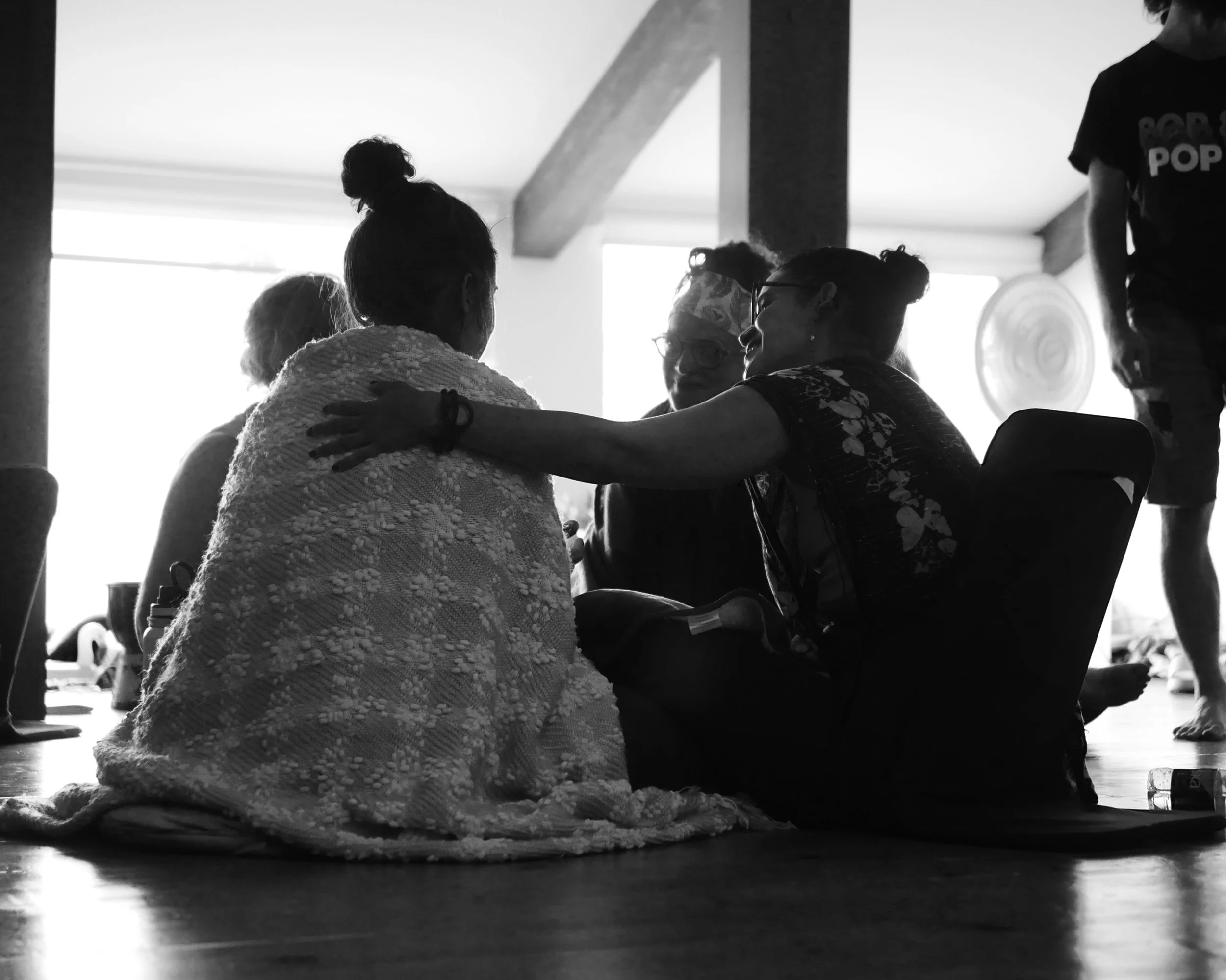 Groupe de personnes assises sur le sol, en train de converser